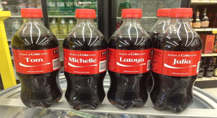 Row of Coca-Cola plastic bottles featuring unique names on the label as part of the Share a Coke campaign